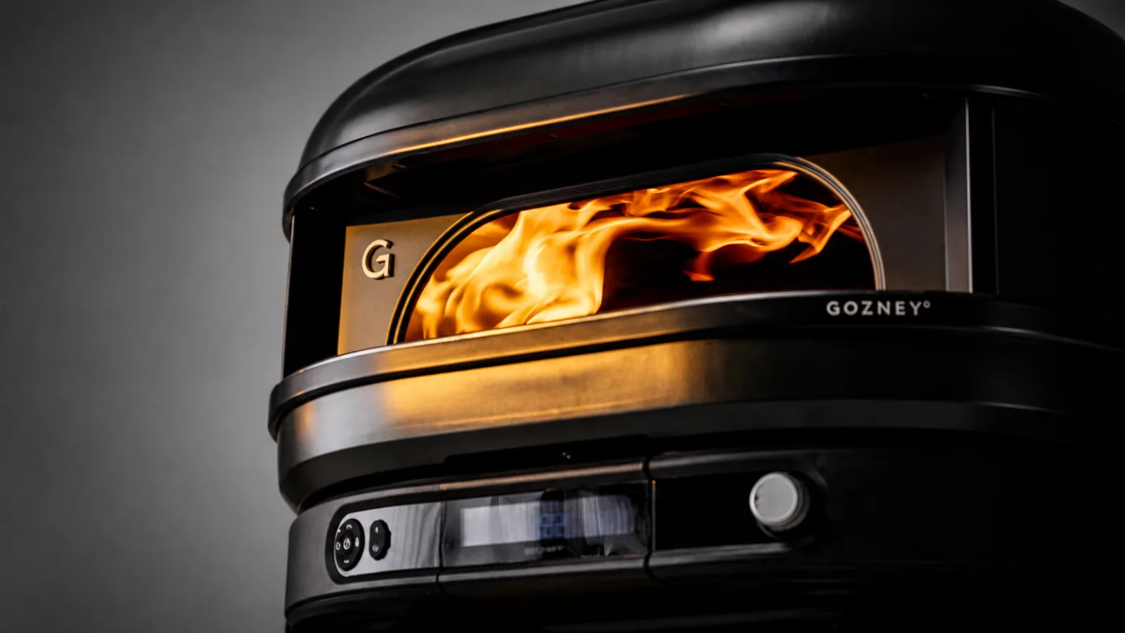 Four Gozney noir vu de face avec sa flamme latérale dans un décor en acier