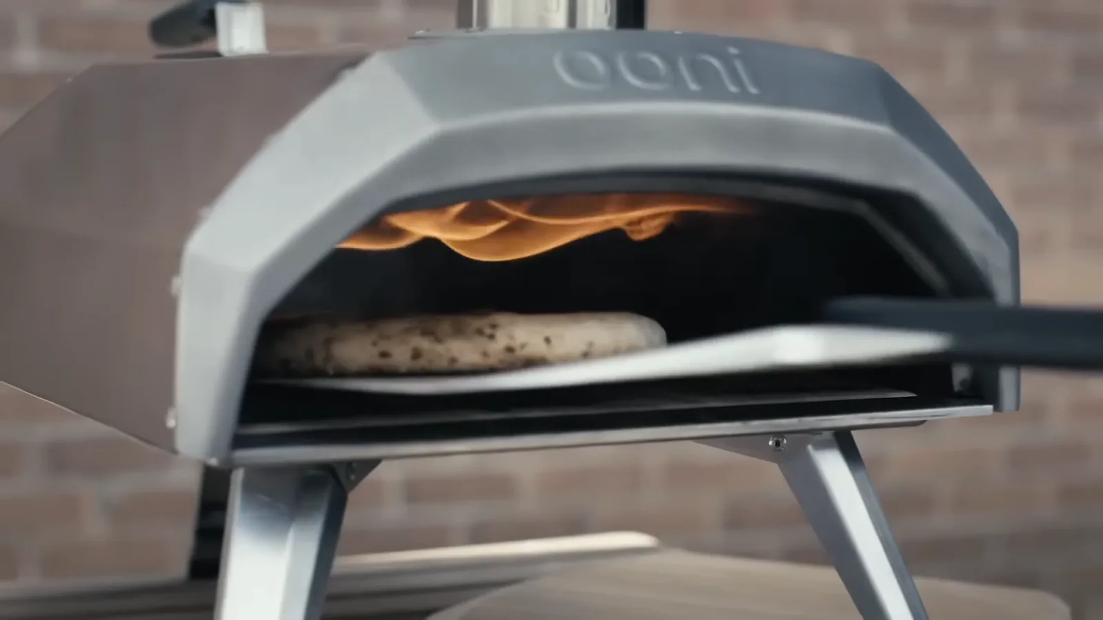 Ooni Karu 12 de première génération avec une pizza et la flamme visible